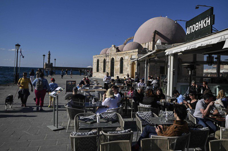 希腊克里特岛哈尼亚市旧城区游客和当地人今年4月20日在咖啡厅露天座位享受悠闲的早晨。法新社(photo:UDN)