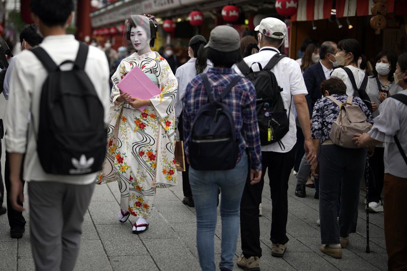 图为日本传统艺妓戴着防护面罩，在浅草寺附近工作的画面。图为示意图，非新闻当事照，与新闻当事人无关。美联社(photo:UDN)