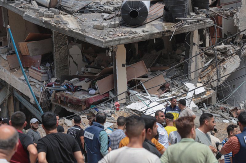 加萨城6日遭遇空袭后，人们查看损毁的楼房。 新华社(photo:UDN)