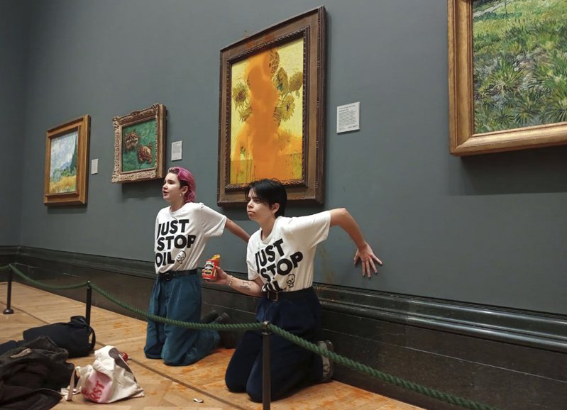 根据社群媒体推特流传的一段影片显示，环保人士今天在英国国家美术馆进行抗议活动时，把装在罐头里的番茄汁泼向荷兰名画家梵谷的作品「向日葵」。图／美联社(photo:UDN)
