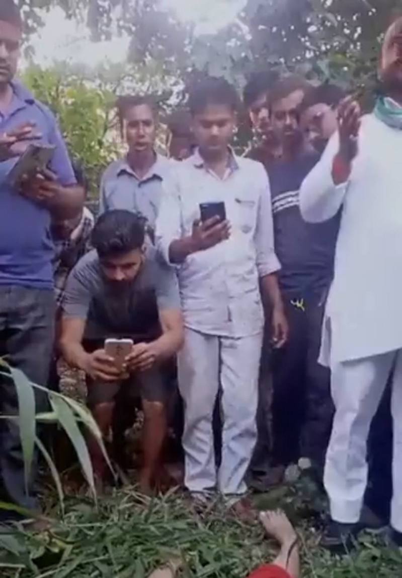 印度北方邦：影片显示一群男子围观拍照，却没有协助拯救躺在草地上的受伤女童（影片截图）(photo:UDN)