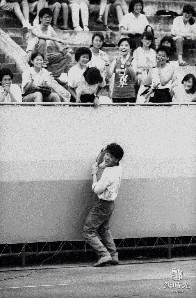 經過三天透不過氣的聯考壓力後，數千名考生三日晚在中華體育場內，藉著由「正良風格創意體」主辦的「七十七年大學聯考生之夜」，丟下了長期以來背負的聯考重壓，學生與歌星周華健同樂。圖／聯合報系資料照（1988/07/03　林少岩 攝影）