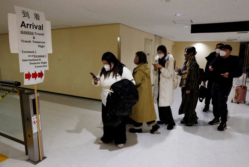 今年初從北京飛抵日本成田國際機場的旅客，正等候接受新冠肺炎檢測。路透