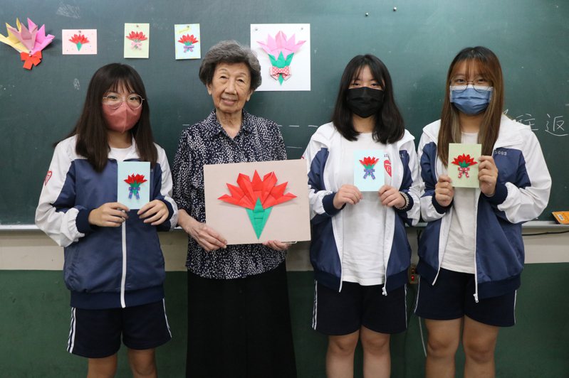 擁有日本摺紙專業證照、教學經驗數十年的長女校友王愛惠，今年已90歲高齡，專程返校教摺紙康乃馨。圖／長女提供