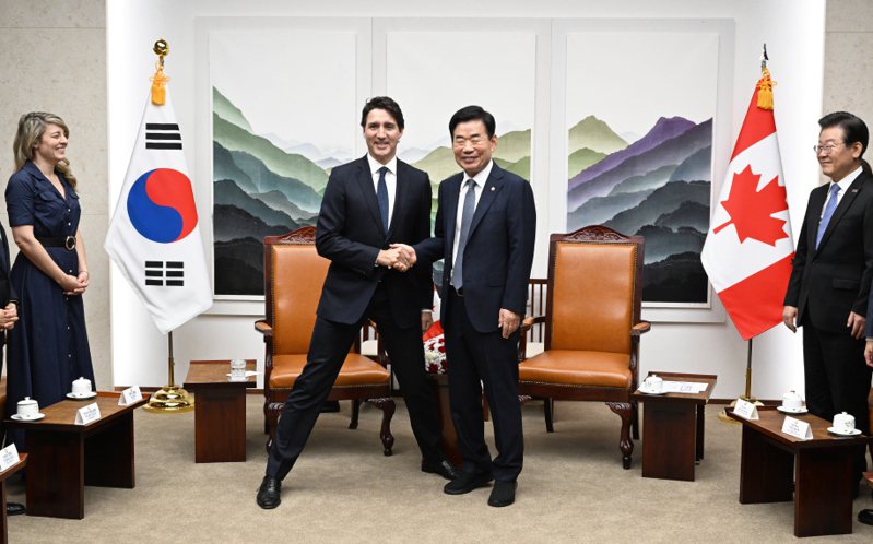 加拿大總理杜魯多｢圖左）17日與南韓國會議長金振杓（圖右）合影時，怕身高落差太大，貼心地把雙腿打開。歐新社