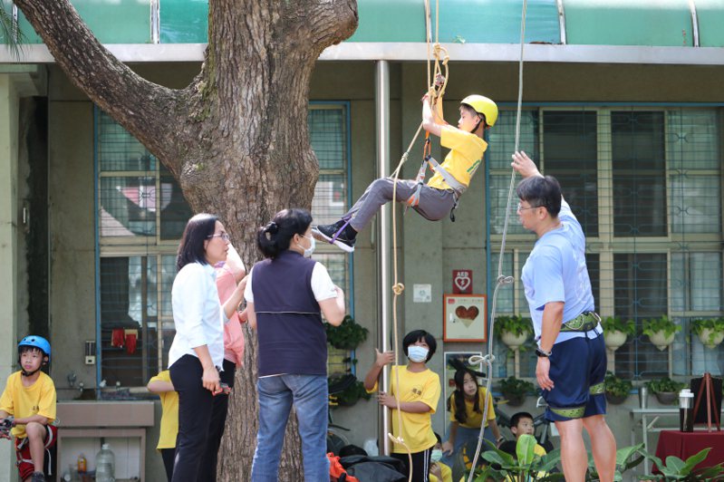 頭份市暑期樂活學習營今年有多達70項營隊，有「攀樹」等新增活動，市長羅雪珠上午到信德國小與學童一同體驗。圖／頭份市公所提供