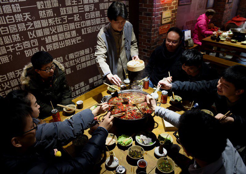 重慶將建國際火鍋村，集聚全球特色火鍋資源。圖為服務員為食客在麻辣火鍋裡煮湯圓。（中新社）