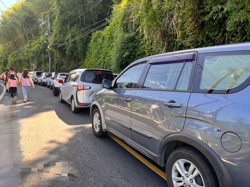 拉拉山國家森林遊樂園區內停車位僅70格，採一進一出方式，今上午6時許就被停滿，上百台車輛在外苦等。圖／讀者提供