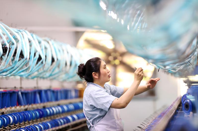 6月財新中國製造業採購經理指數（PMI）錄50.5，較5月小幅下降0.4個百分點。圖為重慶一家絲綢紡織廠生產線。（新華社）