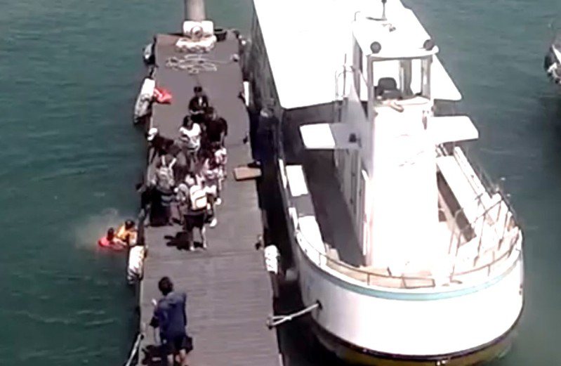 10歲男童不慎被碼頭上不起眼的一塊備用木踏板邊緣絆倒，整個人順勢跌落水中，海巡隊員立即跳下水中將男童救起。圖／海巡署提供