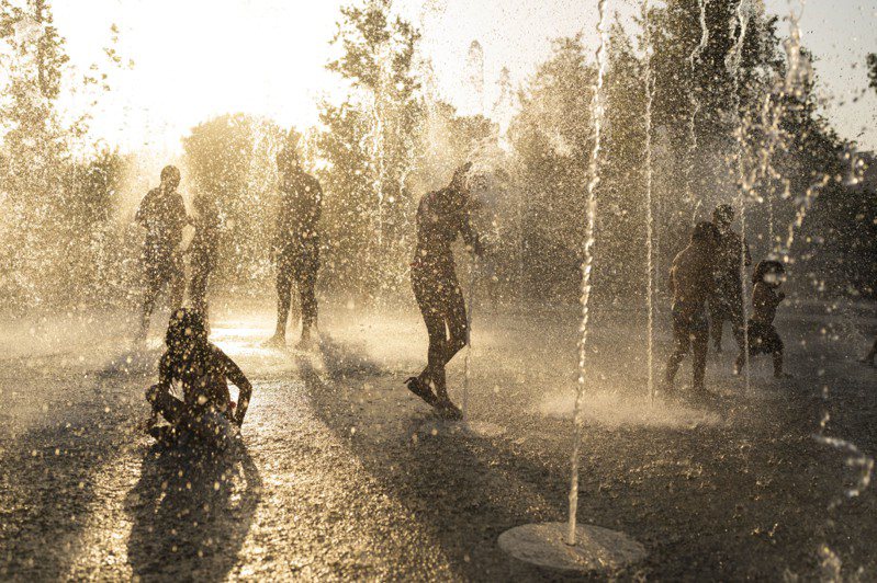 希臘雅典有孩童於熱浪期間在尼亞科斯基金會文化中心的噴泉玩水。（美聯社）