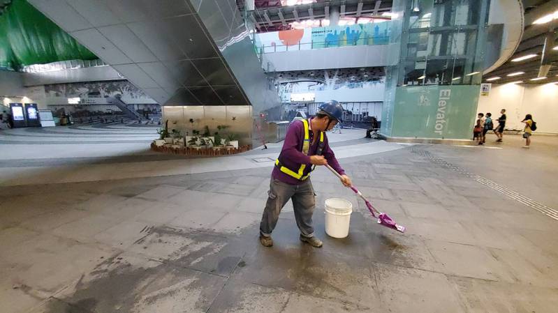 鐵工局的工作人員今早在高雄車站大廳幫忙掃除積水。記者王勇超／攝影