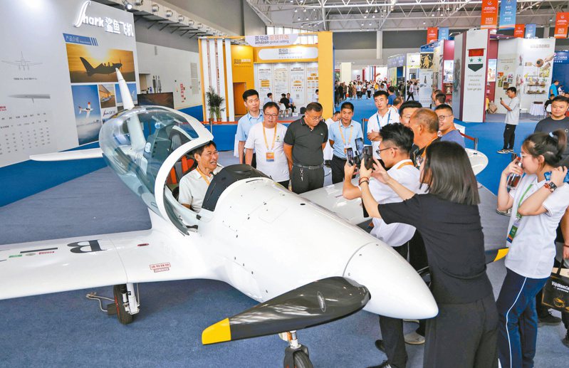 第三屆RCEP區域（山東）進口商品博覽會開幕，客商在會場了解體驗一款國產小飛機。（新華社）