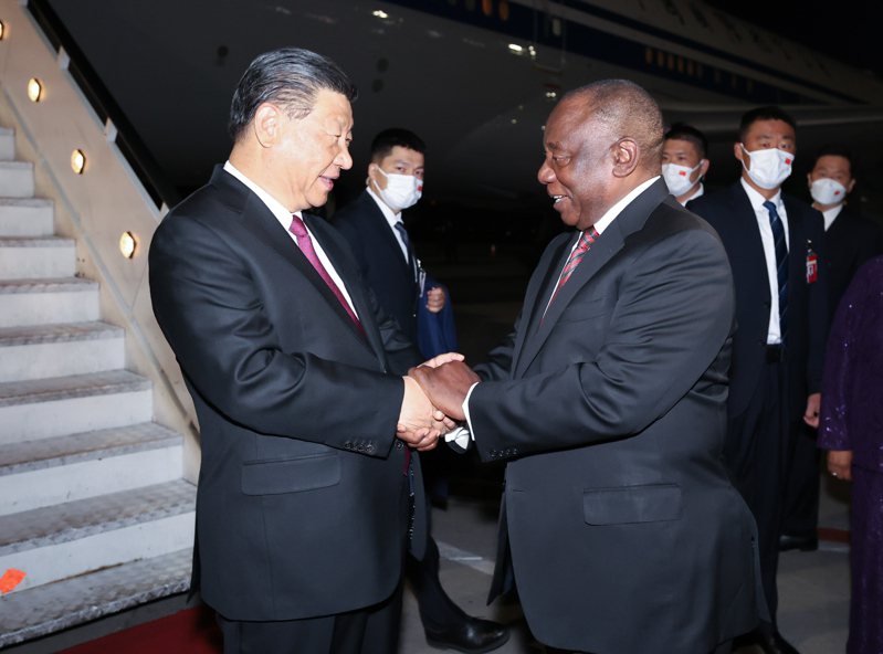 中國大陸國家主席習近平（左）21日抵達南非約翰尼斯堡，南非總統拉馬福薩到場接機。新華社