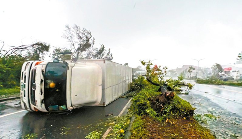 海葵颱風挾帶強風豪雨，台東市區一輛十七噸重的冷凍貨車被掀翻。（中央社）