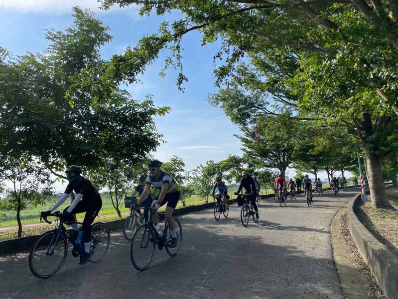 參加「南高一騎GO 低碳輕移動」自行車騎乘活動的民眾，經過樹蔭時享受清風徐徐。圖／高市交通局提供