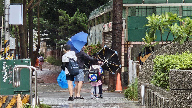 桃園市今天上午風雨不斷，學生上學途中傘被吹開花。記者鄭國樑／攝影