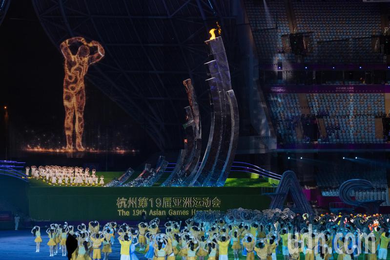 開幕式上現身的「數位火炬人」再次重返熄聖火，面對觀眾比出大愛心展現逗趣的一面，揮揮手後告別後跑離「大蓮花」，象徵杭州亞運正式落幕。特派記者季相儒／攝影