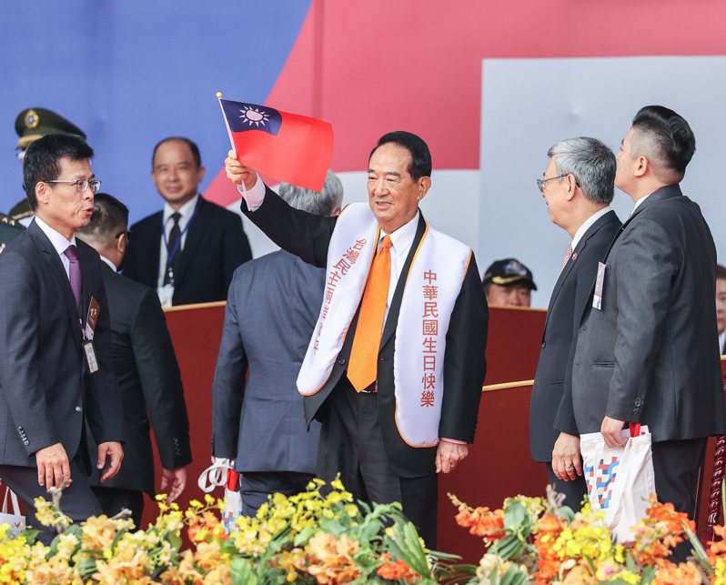 國慶大典上，親民黨前主席宋楚瑜（中）穿著自製背心，印有「中華民國生日快樂」，並且在結束時特別起立揮舞國旗。記者曾原信／攝影
