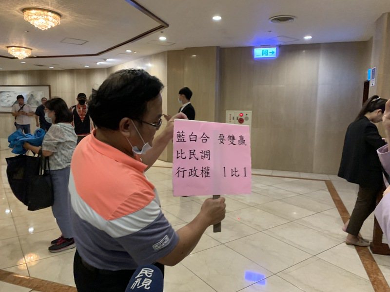 民眾黨、國民黨在野力量整合會議今天下午在台北福華飯店舉行，場外一名蕭先生手舉「藍白合比民調，要雙贏」標語，表態支持藍白合。記者林縉明／攝影
