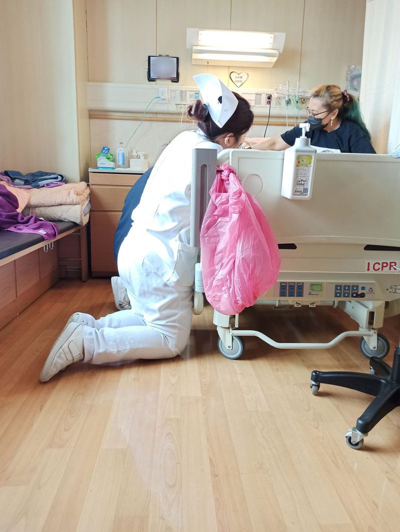 一名護理師跪在病床旁為病人打針。圖／翻攝自臉書社團爆廢公社二館