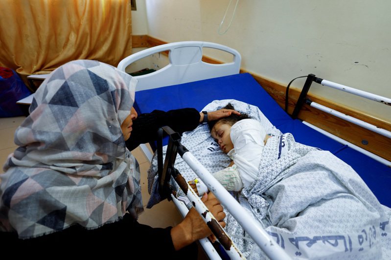 一名4歲巴勒斯坦女童在以色列空襲中受傷，父母和手足等14名家人已喪生；她14日由祖母陪同，待在加薩南部甘尤尼斯的一所醫院。路透
