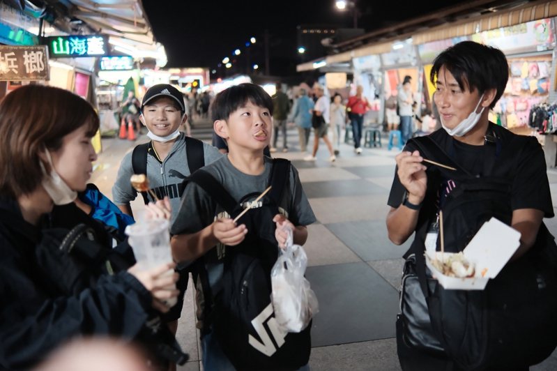 日本與那國小學及久部良小學共17名學生來到花蓮畢業旅行，16日第一個行程前往東大門夜市品嚐台灣小吃臭豆腐。（花蓮市公所提供）中央社