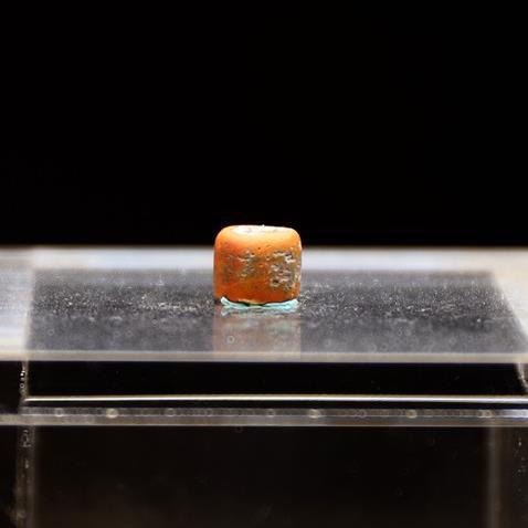 花蓮崇德遺址出土一粒紅色玻璃珠，經送美國實驗室分析，原來是出自南亞印度一帶的文物。圖／花蓮縣文化局提供