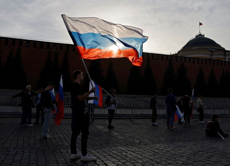 一名年輕人在位於俄羅斯莫斯科的一處廣場上揮舞國旗。路透社
