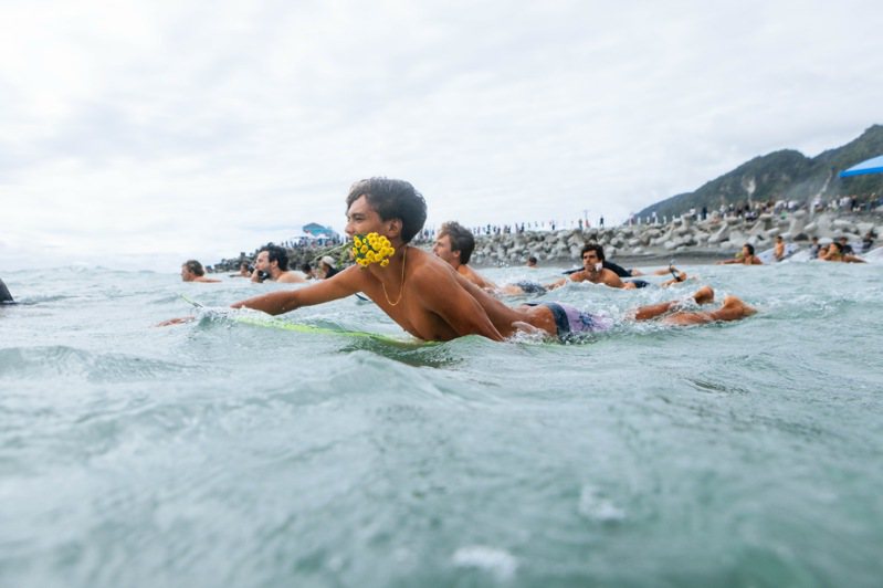 衝浪選手口咬鮮花划入大海，以夏威夷傳統儀式悼念FEBRI ANSYAH。圖／台東縣府提供
