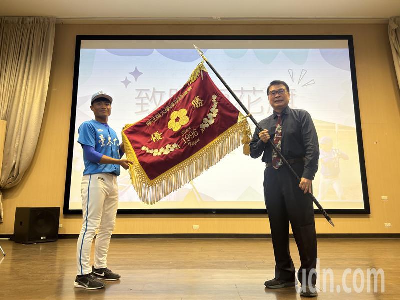 成軍十年終於拿下梅花旗，東大棒球隊隊長王騰玉（左）將梅花旗獻給學校，由校長曾耀銘（右）代表收下。記者徐白櫻／攝影