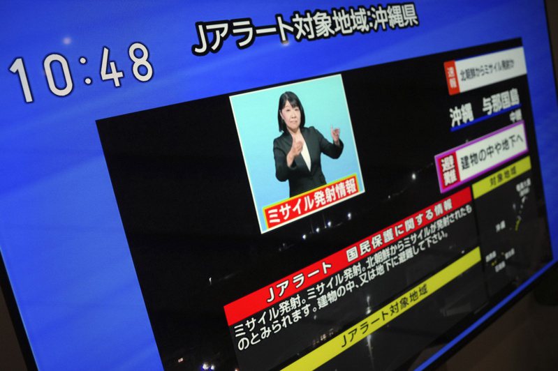 圖為日本的電視台報導全國瞬時警報。(美聯社)