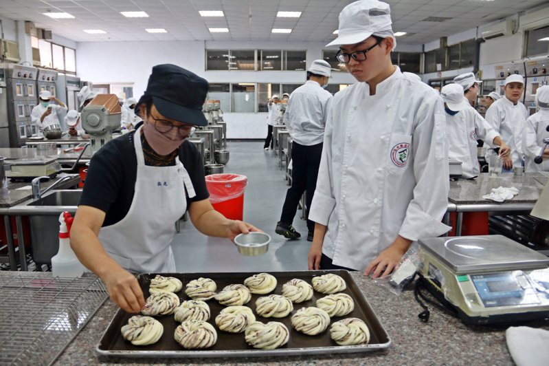 弘光科大食科系一年級馬來西亞境外生黃子軒（右）上麵包實作課。記者游振昇／攝影