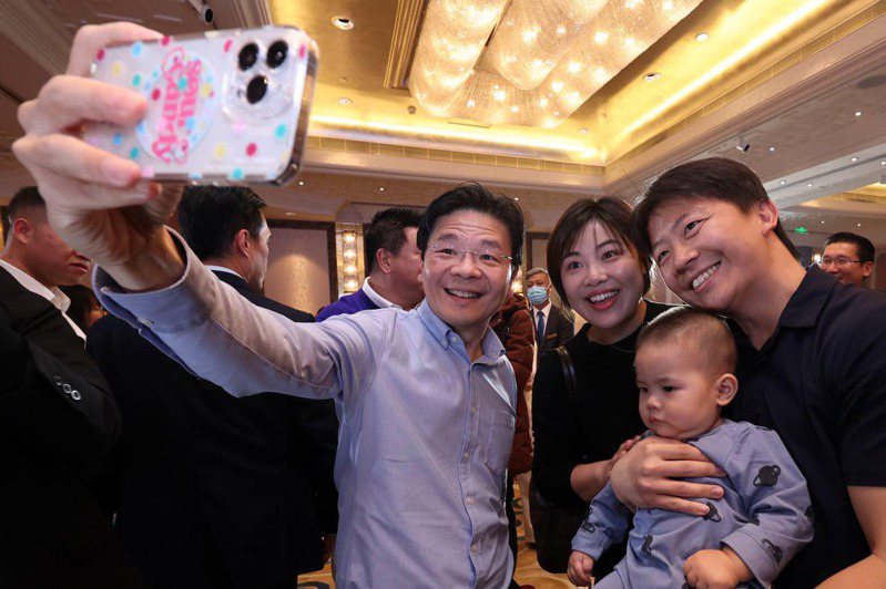 新加坡金融管理局7日宣布，開展中國與新加坡之間的跨境數位人民幣試點，將允許兩國旅客使用數位人民幣進行消費。圖為黃循財（左）5日抵達北京後在北京與新加坡人齊聚。（圖／取自facebook@Lawrence Wong）