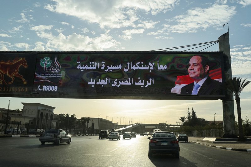 埃及民眾今天前往投票所參與選舉，總統塞西有望贏得他的第3個任期。圖為在即將舉行的總統選舉之際，車輛駛過總統候選人、現任埃及總統塞西的廣告看板。路透
