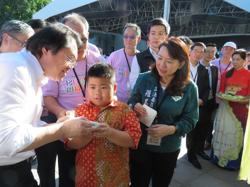 內政部長林右昌（左）把一塊娘惹糕送給新住民小朋友。記者黃寅／攝影
