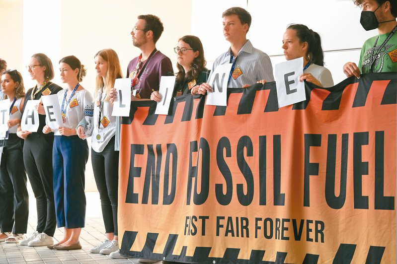 環保人士十三日在杜拜聯合國氣候峰會場邊示威，要求停止使用化石燃料。（美聯社）