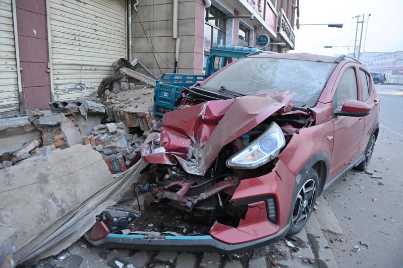 大陸甘肅省積石山18日深夜發生規模6.2強震，造成甘肅、青海百餘人死傷。圖為積石山縣大河家鎮街邊受損的車輛。（中新社）