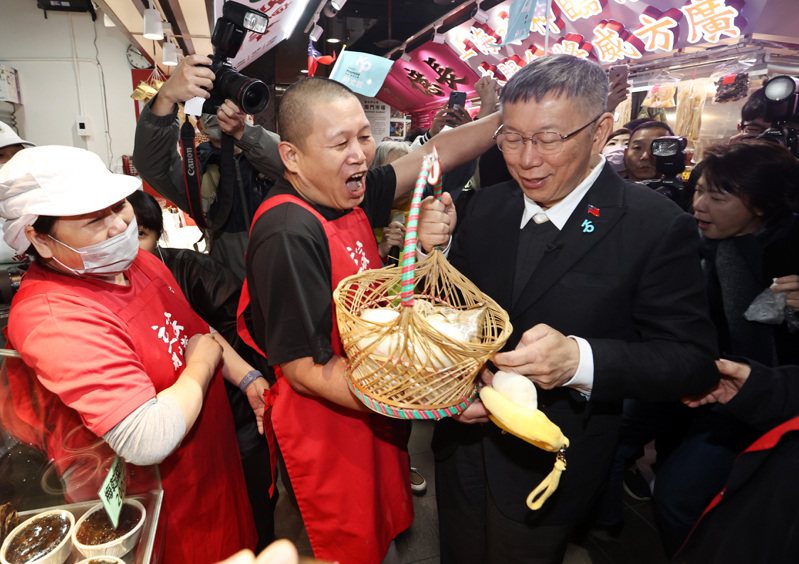 民眾黨總統候選人柯文哲（右）上午以台北市前市長的身份「回娘家」到南門市場，受到支持者的熱烈歡迎，攤商送了一籃粽子預祝他高票當選。記者杜建重／攝影