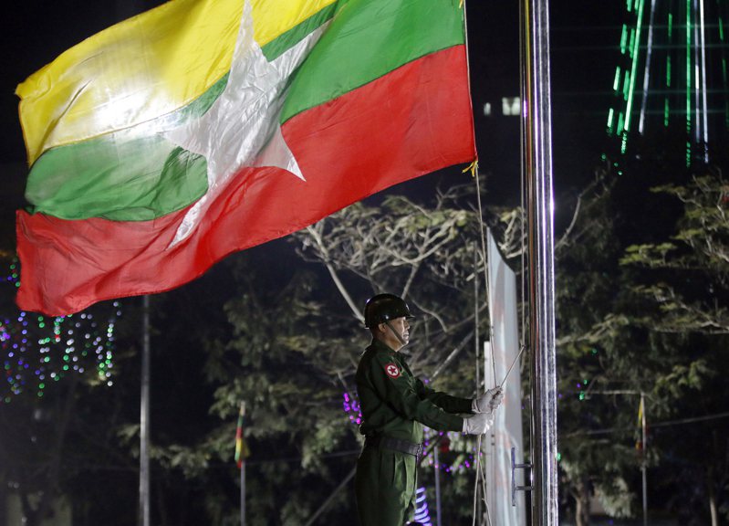 圖為一名緬甸軍人在紀念日時升起該國國旗。示意圖，非新聞當事照。美聯社