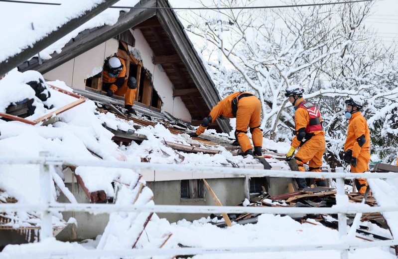日本消防員8日在石川縣珠洲市震災區倒塌房屋尋找失蹤民眾。歐新社