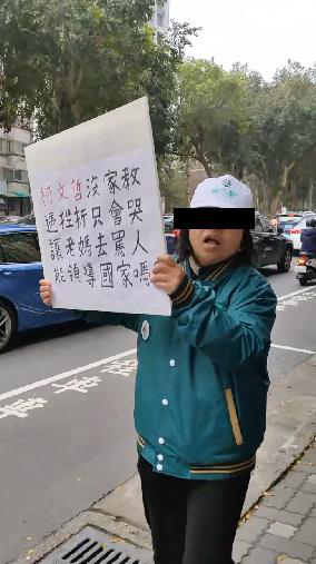 新竹市街頭今天出現2名男女在路口舉牌，一人疑似綠營支持者批評民眾黨總統候選人柯文哲「沒家教」。記者張裕珍／翻攝