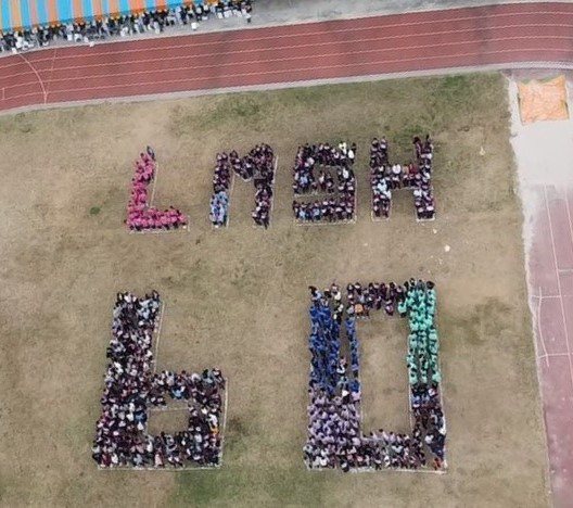六百多位師生在操場排出校名縮寫「LMSH 60」，慶祝學校60歲生日。圖／黎明中學提供