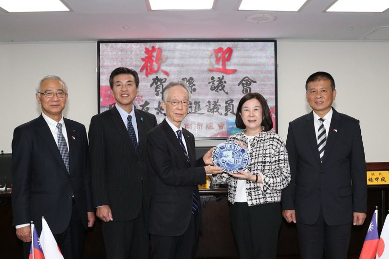 台南市議長邱莉莉（右二）致贈佐賀縣議會印有台、日國旗的蘭花。圖／台南市議會提供