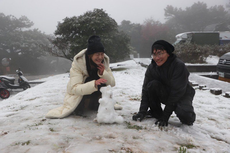 台北陽明山今天凌晨降下瑞雪，許多民眾到陽明山賞雪，在二子坪停車場堆起雪人。記者陳正興/攝影