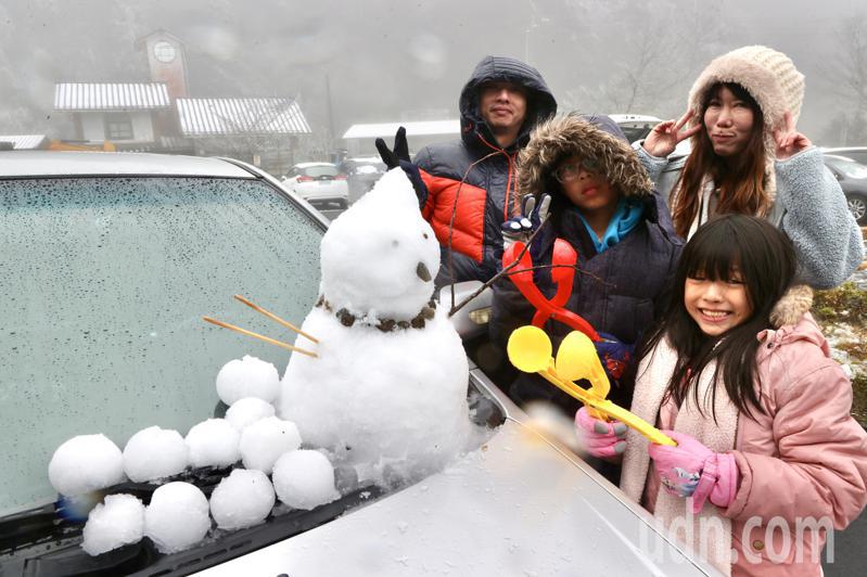 全家一起堆雪人，小朋友「運送」雪，父親負責製作雪人，齊心完成追雪任務。記者黃義書／攝影