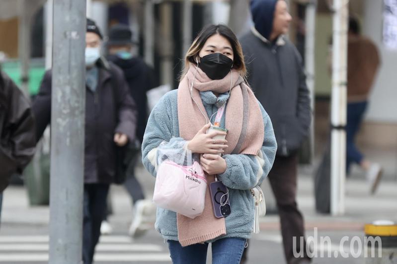 台北市今天陰雨綿綿，加上寒流的冷風天，民眾脖子裹上圍巾、穿厚衣服出門，抵禦寒風濕冷天氣。記者陳正興／攝影