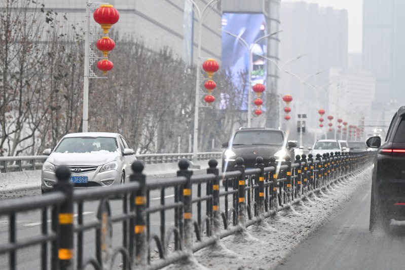 2008年初肆虐中國華南的雨雪天氣，今年恐將在華中重演。由於進入春運時期，華中雨雪天氣已造成班機取消及高鐵列車嚴重誤點，部分旅客在停電而中斷供暖的車內及車站滯留，返鄉之路受阻。圖為市民在雨雪天氣中出行。新華社