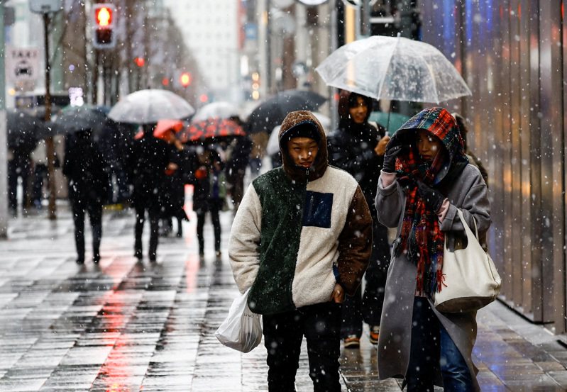 日本东京银座街头5日可见降雪，不少民众撑伞而行。路透(photo:UDN)