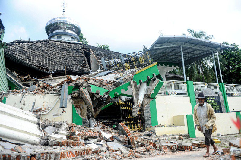印尼東爪哇22日下午發生芮氏規模6.5地震，以及前後多次地震。圖為一名男子走過印尼東爪哇島巴文島坦巴克村一座受損的清真寺。新華社
